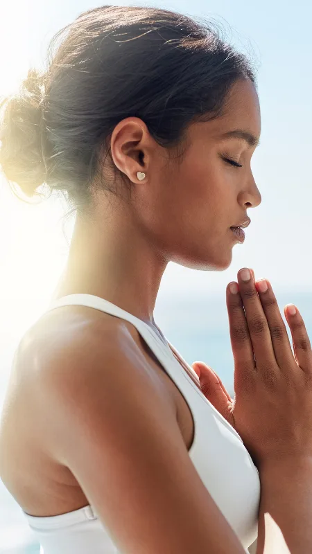 A woman meditating with her hands together