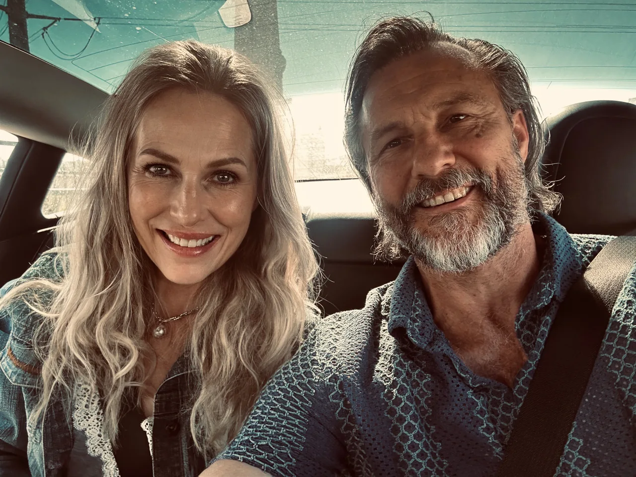 Jay and Cory Fiset smiling together in a car